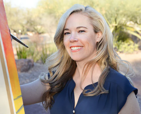 Julie Bonner painting with a brush outdoors
